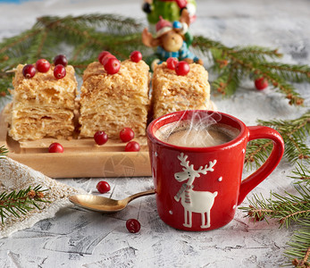 红陶瓷杯黑咖啡和一小片面饼拿破仑奶油装饰与红莓喜庆背景图片