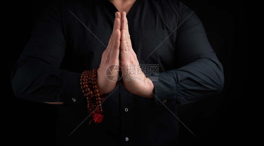 两只男手在乳前搭配穿黑衬衫的男子展示了Namaste祈祷泥土图片