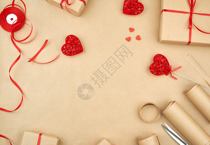扫码有礼棕色Kraft纸包装的礼品袋和绑有红丝带心一套用于礼品制作的物礼包装件设计复制空间背景