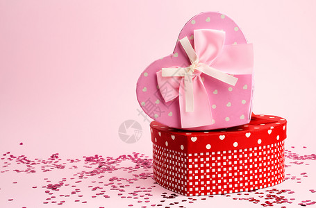 粉红和的盒以背景节日的心结和弓为形式的红粉和礼物盒背景图片