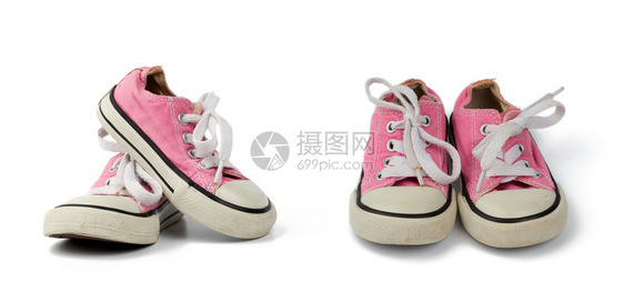 一双粉红色的儿童纺织运动鞋白色背景上有白色鞋带旧鞋套装图片