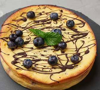 黑色盘子上烤圆的干酪奶锅炉饼最美景味和健康的甜点图片