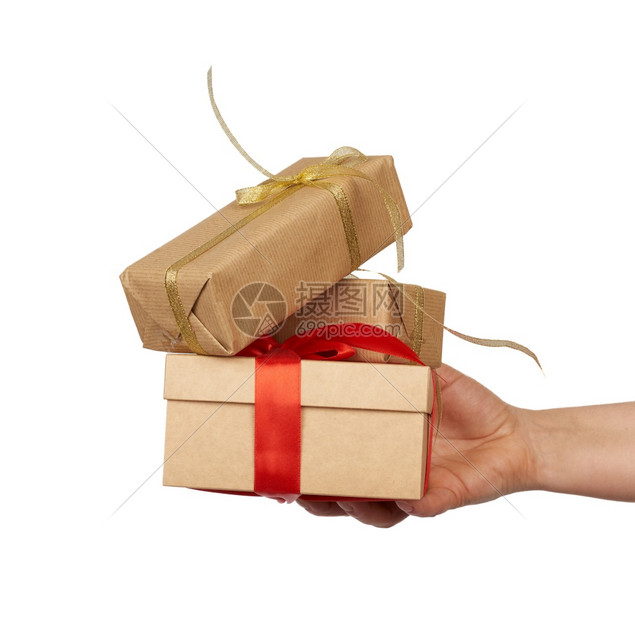 手握着一堆包的礼物装在棕色手纸上绑着丝弓对象在白色背景上隔离图片