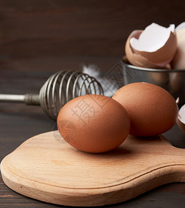 木板上的鸡蛋和后面的鸡毛图片