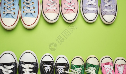 绿色背景顶层观点概念家庭与团队友谊复制空间上多彩色厚体型不同大小的纺织运动鞋背景图片