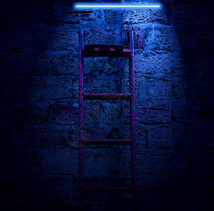 夜幕神秘场景在砖墙背的夜幕下在砖墙背景上竖起金属楼梯和发亮蓝灯图片