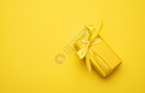 黄长方形盒礼品包在黄纸上绑有丝顶视图图片
