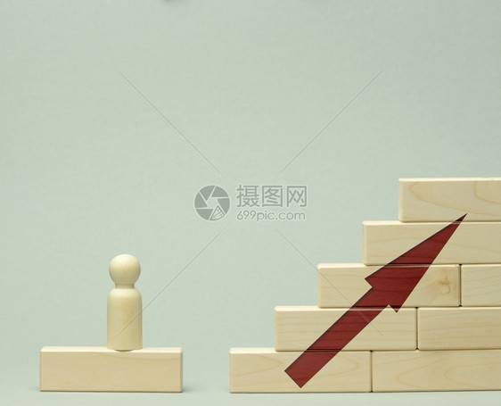 一个人的木制雕像站在一个楼梯上由第一步的路障制成楼梯上实现在商业职发展启动方面的既定目标概念图片