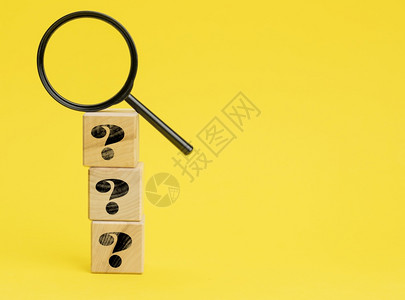 含有问题标记和黄色背景放大镜的木制立方块寻找未知问题的答案解决问题的概念查找信息背景图片