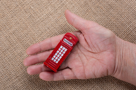 英国电话亭手拿着棕色背景的电话亭背景