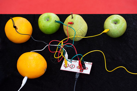 与设备以及显示的苹果橙子和梨连接的电缆图片