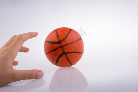手持橙色篮球模型白背景图片