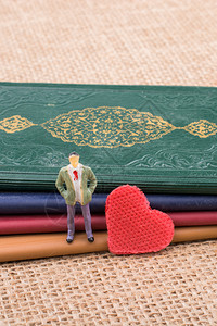 男人雕像站在小书上的心脏旁图片