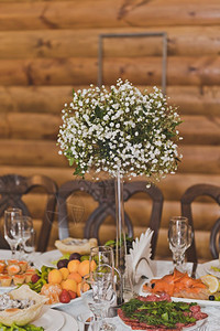 花束装饰的节日餐桌桌上摆着一束美丽的白色小花上面点缀着9273种水果图片