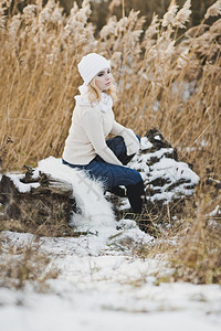 一个女孩在红雪覆盖厚的稻草中冬季画像在湖边的草原916图片