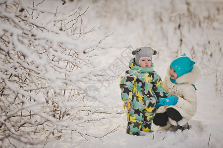 幼童在冬季雪林背景下的肖像两个幼童在雪林中行走918背景图片