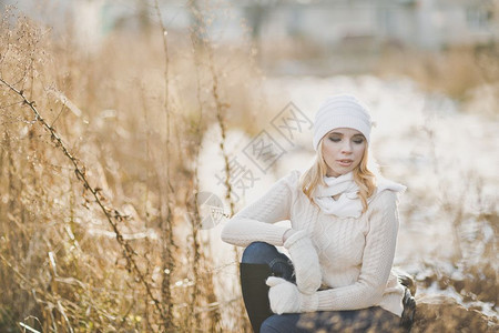 一位女孩坐在9183号公路旁边的一块大石头上冬季肖像背景图片