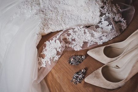 新娘的鞋大耳环和米色鞋8021年仪式前的首饰和衣服背景