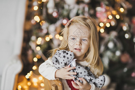 一个小女孩坐在圣诞树附近期待奇迹7314图片