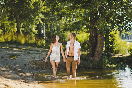 沿着湖边的海滩走一条年轻夫妇沿着水边走629背景图片