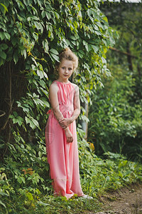 一个穿着漂亮衣服的女孩肖像一个穿着长裙的女孩肖像在花园灌木丛中643图片