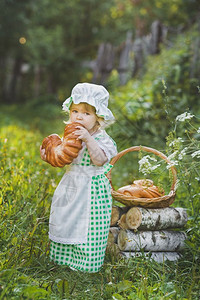 一个孩子在花园里吃新鲜的面包图片
