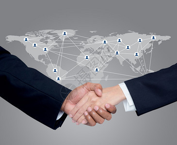 与全球通信网络背景的人握手企业图片