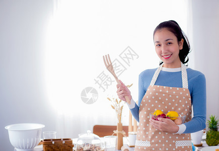 漂亮的女人在厨房里笑着拿碗的漂亮女人图片