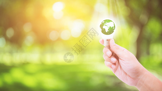 根据自然背景环境和生态概念手持一个带有绿色能源世界的灯泡由美国航天局提供的这一图像要素图片