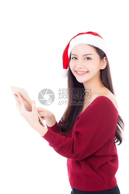 美丽的肖像年轻亚洲女穿着红色礼服戴圣诞帽手持平板孤立在白色背景女孩与连接数字通信概念图片
