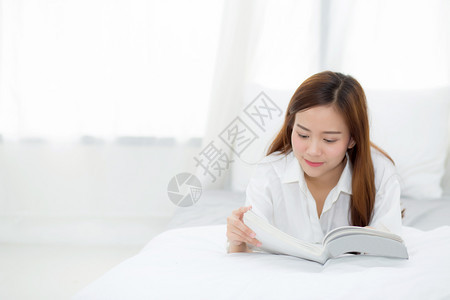美丽的肖像年轻亚洲女放松谎言读物在家里的卧室女孩学习文教育和生活方式概念图片
