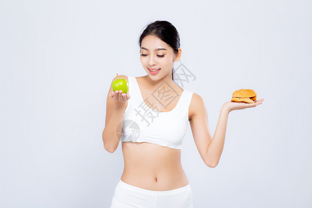 美丽的年轻女瘦弱饮食选择新鲜沙拉蔬菜和汉堡与白种背景隔绝食物健康控制体重下降与卡路里营养和生活方式概念图片