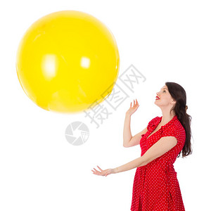 穿红裙子的美女抓着白底孤立的黄气球图片