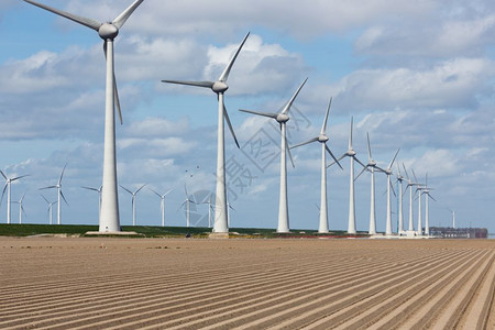 荷兰风力涡轮机和春初犁田条纹的荷兰风景背景图片