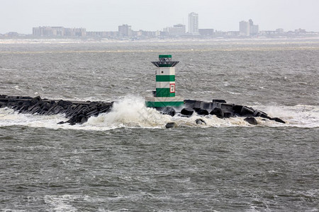 荷兰有灯塔和风暴大海的码头背景是IJmuiden的房屋荷兰有灯塔和风暴大海的IJmuiden号码头图片