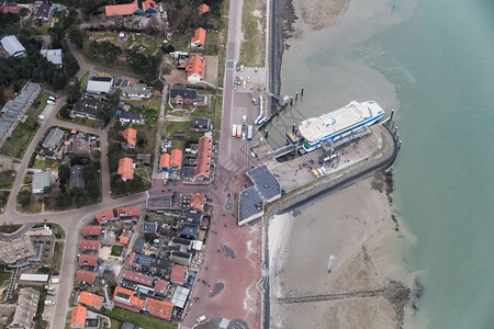 空中与有下船乘客的村渡口和码头站一起观看荷兰的Vlieland河空中与码头和渡口站一起观看荷兰的Vlieland岛图片