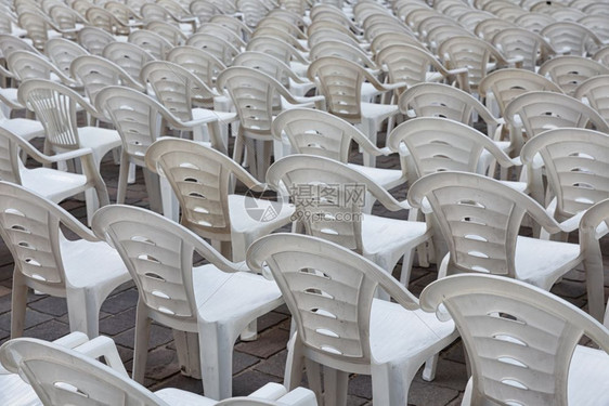 白塑料椅子排成一为音乐会或表演的来访者准备就绪图片