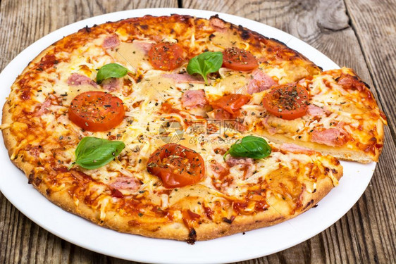 带火腿奶酪西红柿和烤肉的披萨工作室照片带火腿西红柿和烤肉的披萨图片
