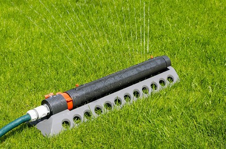灌溉系统喷水器在绿草坪上浇水工作室照片图片
