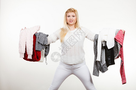 时装服两难概念妇女拿着一大堆衣服不能决定穿什么图片