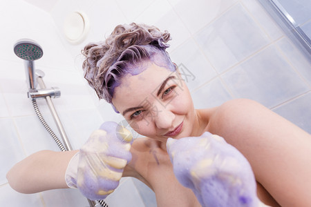 女在头发上涂彩色洗水女有紫色洗发制品在家里染金色女在头发上涂彩色洗水图片