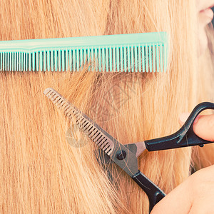 剪裁和概念金发女郎剪裁和梳理她那直滑的光发型专业家制作新的柔软发型女人剪裁光滑的发型图片