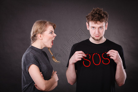 背叛和分手关系年轻夫妇争吵持有红袜字符号暴怒的金发女人对男大喊叫消极情绪心碎的年轻夫妇图片