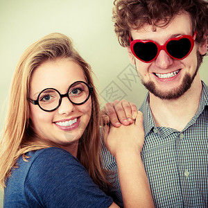 快乐的年轻男人心形眼镜和女人微笑的朋友在工作室的情侣快乐夫妇男女眼镜图片