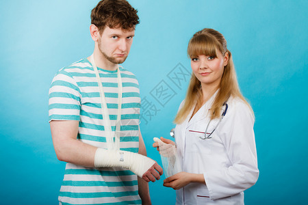 保健和护手腕骨折的青年男子看女医生绷带专家手腕骨折的男医生图片