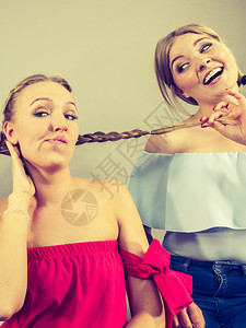 两个年轻美女在争吵时互相生气争吵拉扯头发友谊争斗和妒忌问题图片