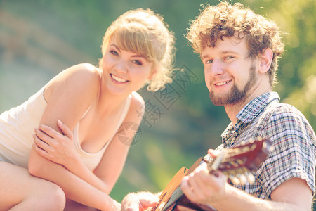 冒险旅游一起享受暑假年轻夫妇旅游者在露营时玩吉他图片