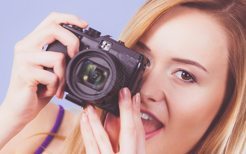 拍照片的女摄影师拍照片的金发美女带着紫色蓝底照的金发笑脸女人蓝相照的金发美女图片