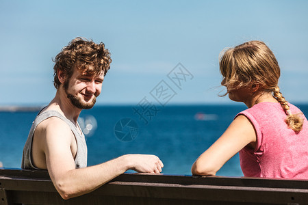 遇见恋人一对夫妇在海边约会露天年轻女孩和男人坐在长凳上夏天的爱夫妇和女人在户外约会背景