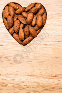 整个食物对健康有好处心脏形状的杏仁木板面背景图片